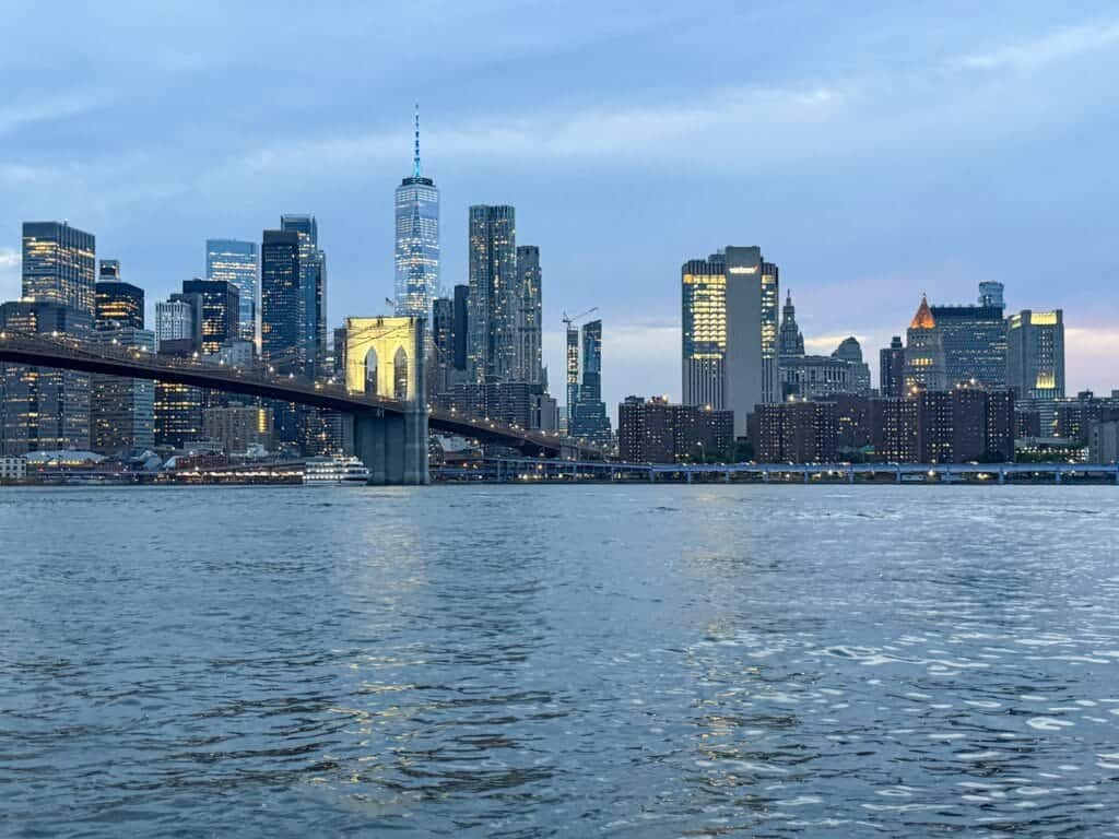 Widok po zachodzie słońca na Manhattan spod Brooklyn Bridge z nabrzeża Brooklynu
